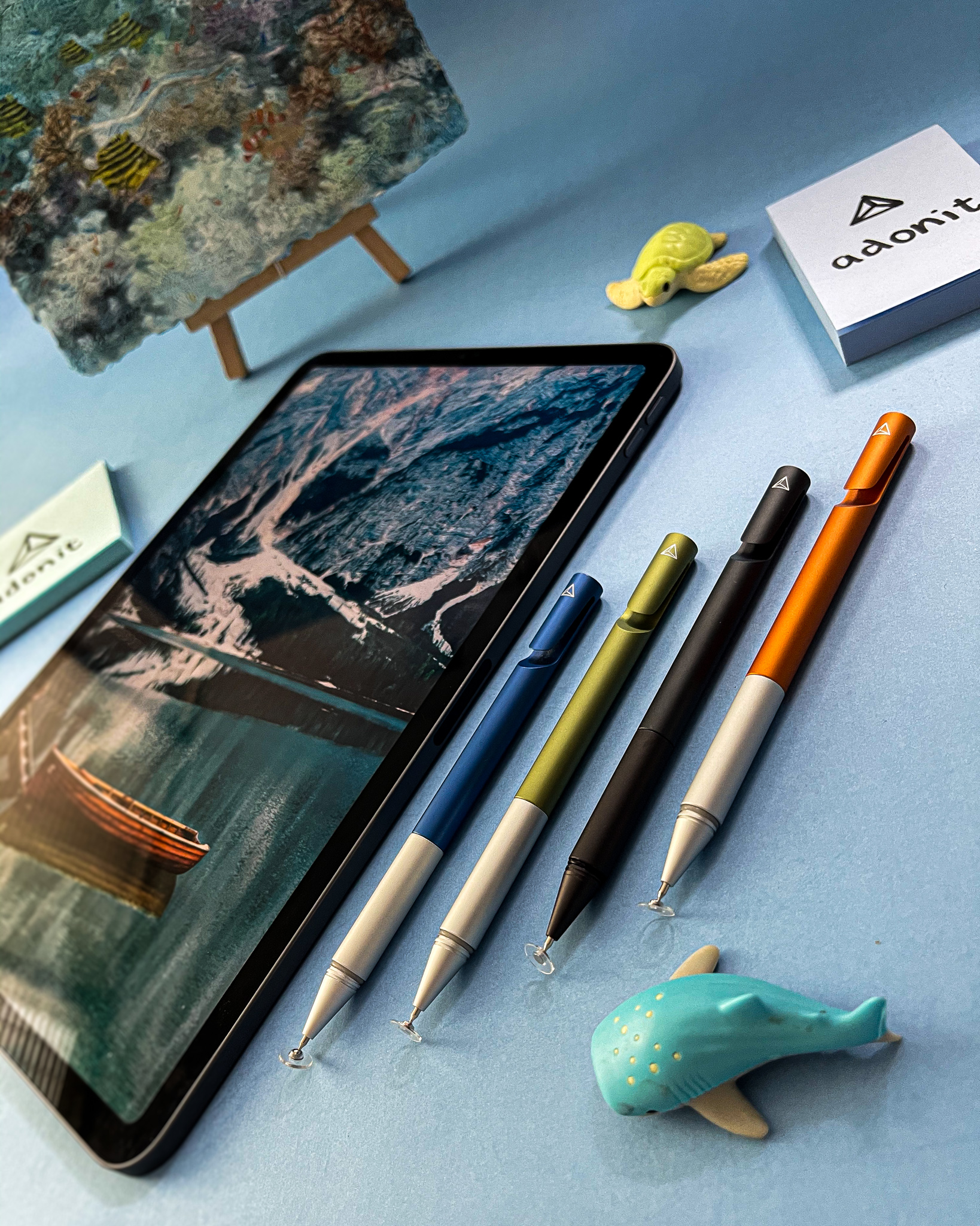 Coloured pens with a mountain lake on iPad and sea-life toys