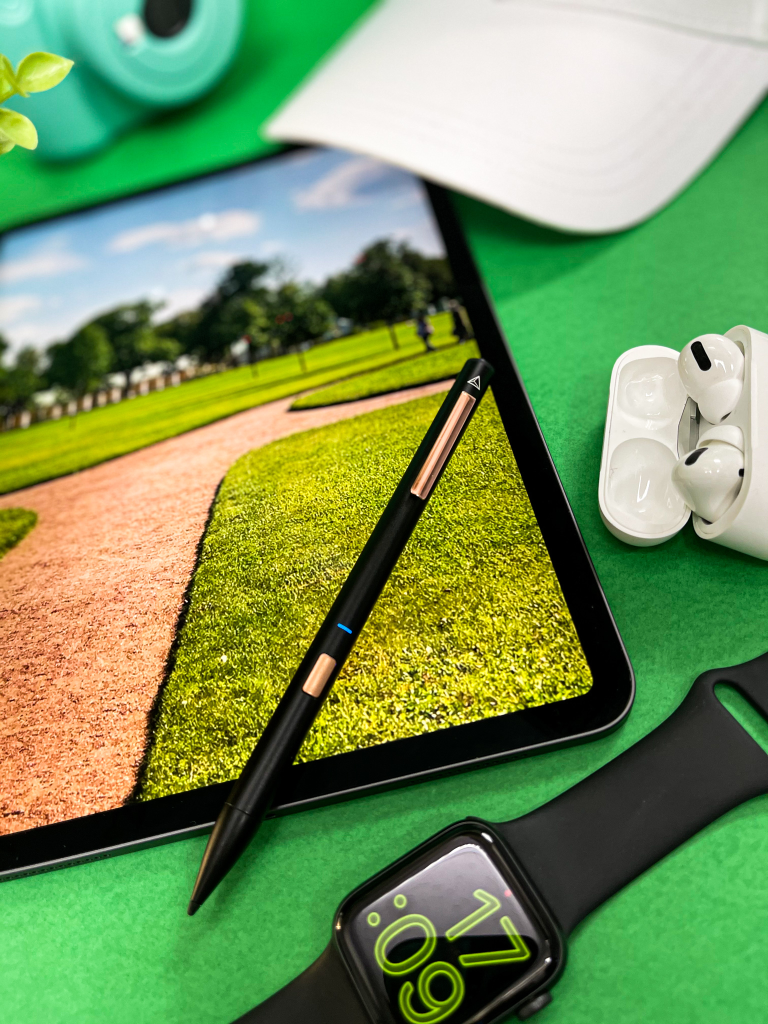 Golf green on iPad, green flat-lay with camera and cap