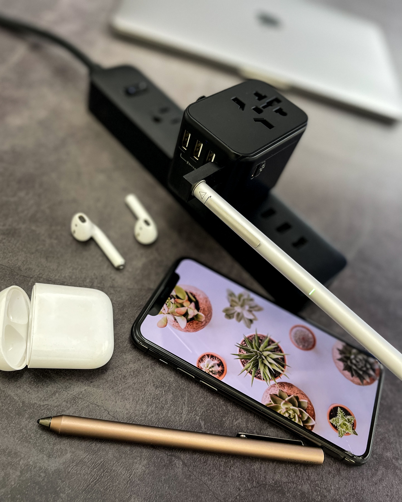 Phone, pens and power strip flat-lay
