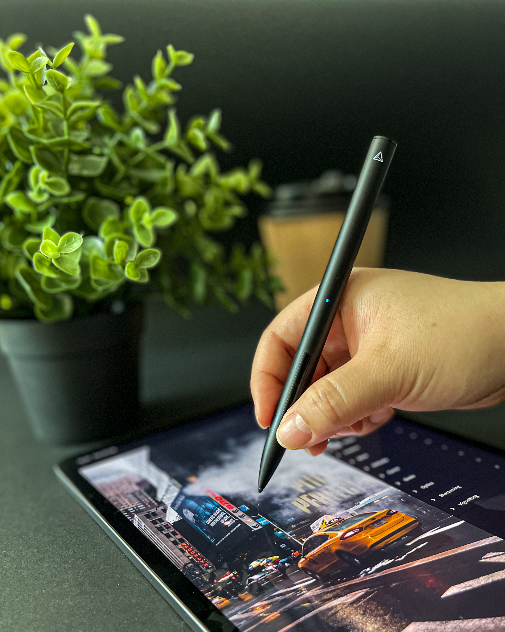 Retouching a city photo on iPad beside a plant