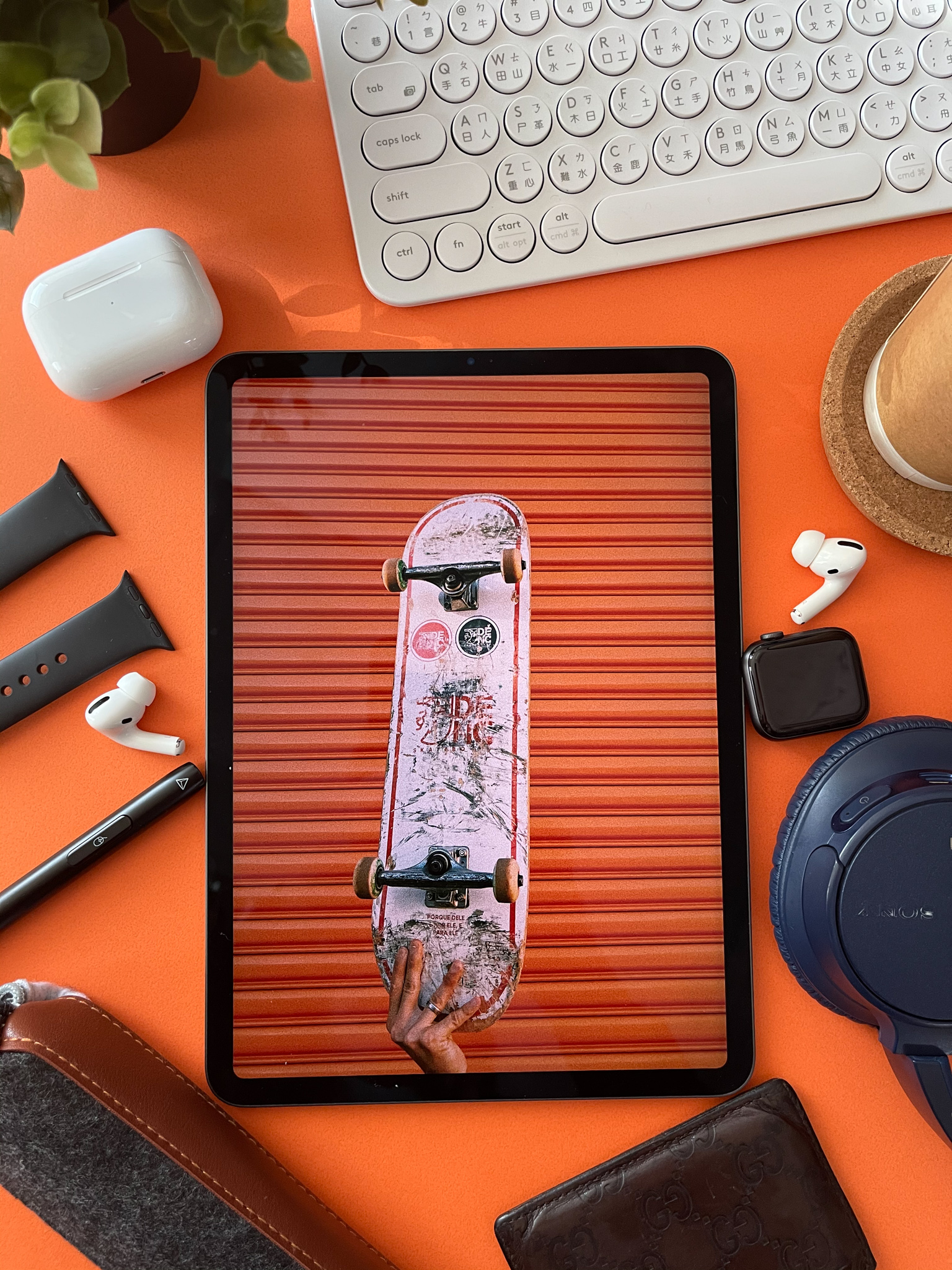 Skateboard wallpaper on iPad, orange desk with watch bands